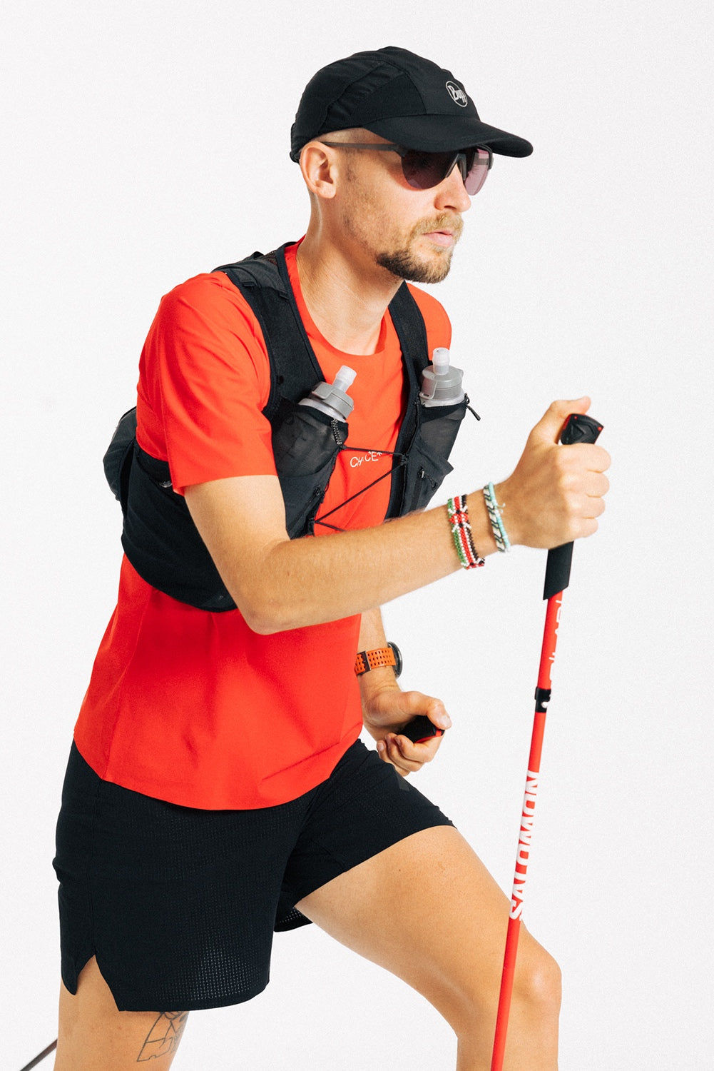 An ultra runner is shown against a white background wearing a red Chance Running ultra tee and black running shorts.