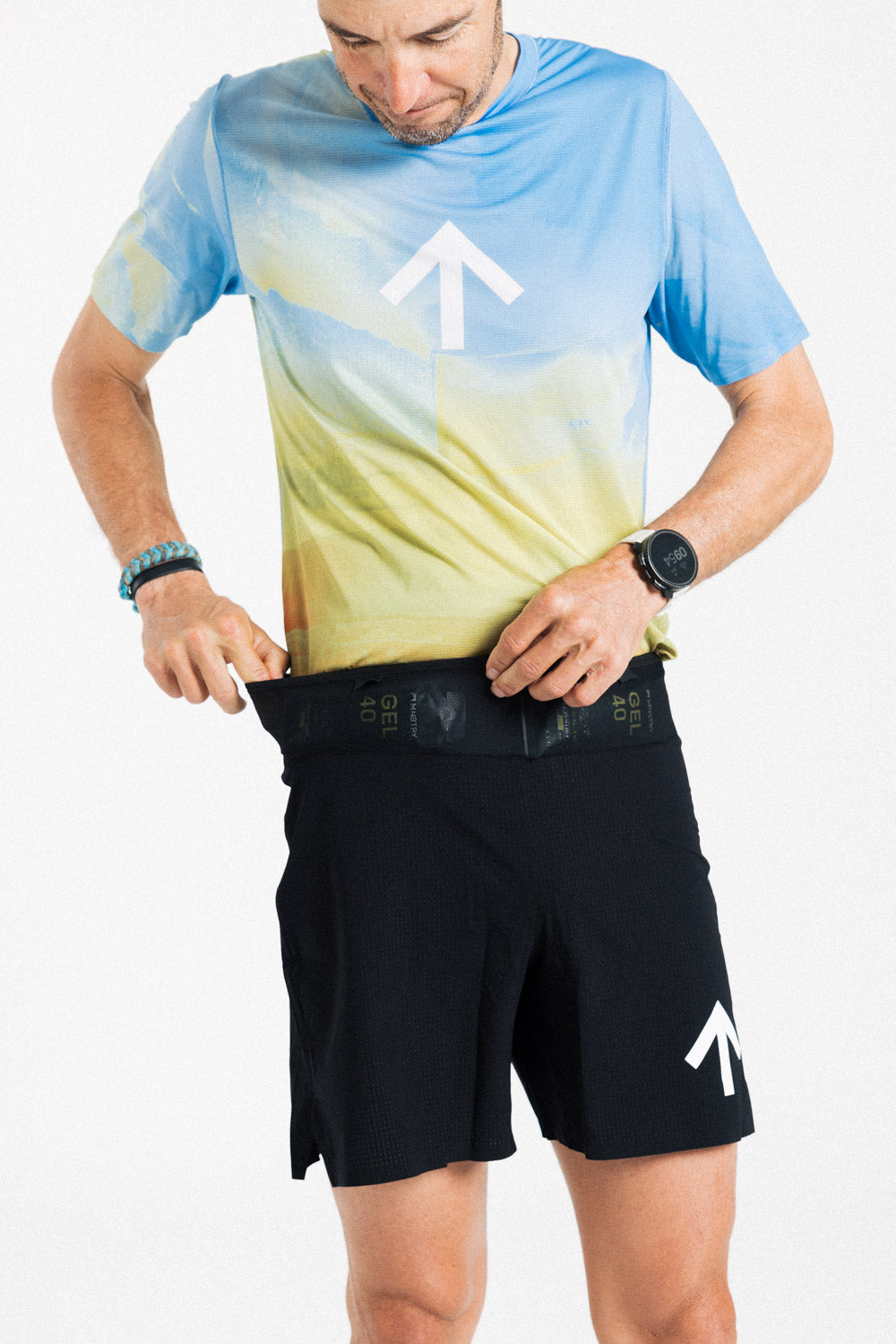 Male runner reaching into the front waistband pocket of the AROW Marathon Short v.2 in Black and White