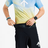Male runner reaching into the front waistband pocket of the AROW Marathon Short v.2 in Black and White