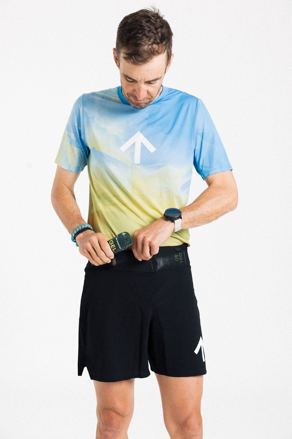 Male runner storing a soft flask in the waistband of the AROW Marathon Short v.2 in Black and White