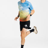 Male runner mid-stride in the AROW Marathon Short v.2 in Black and White with a blue and yellow gradient tee