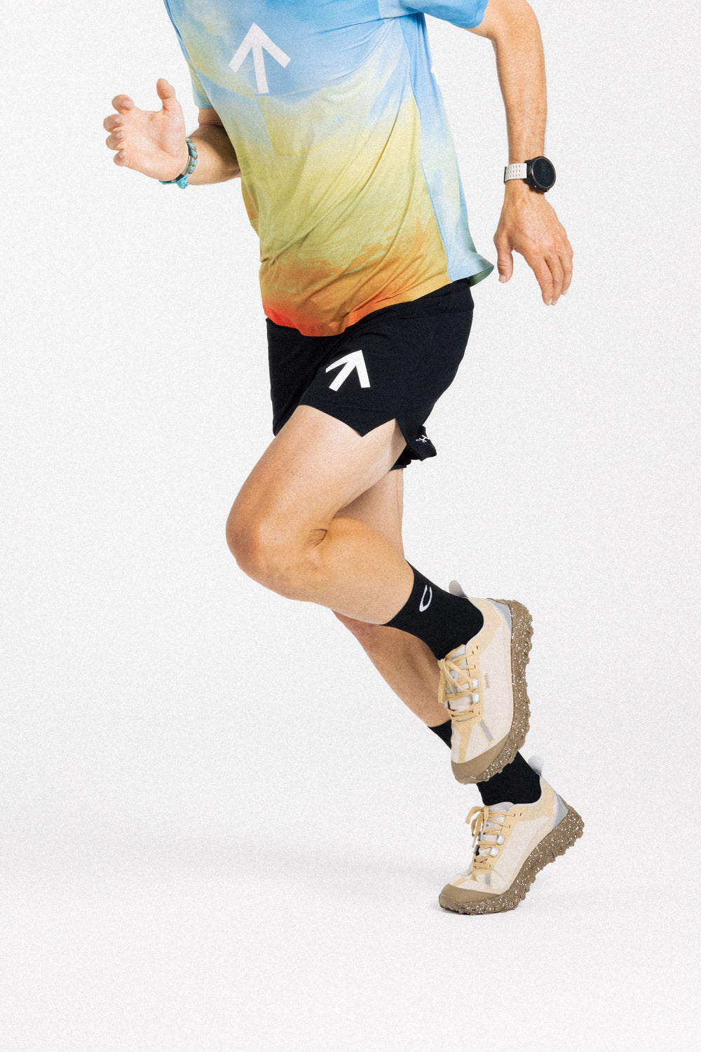 Runner mid-stride in the AROW Marathon Short v.2 in Black and White with a blue and yellow gradient tee