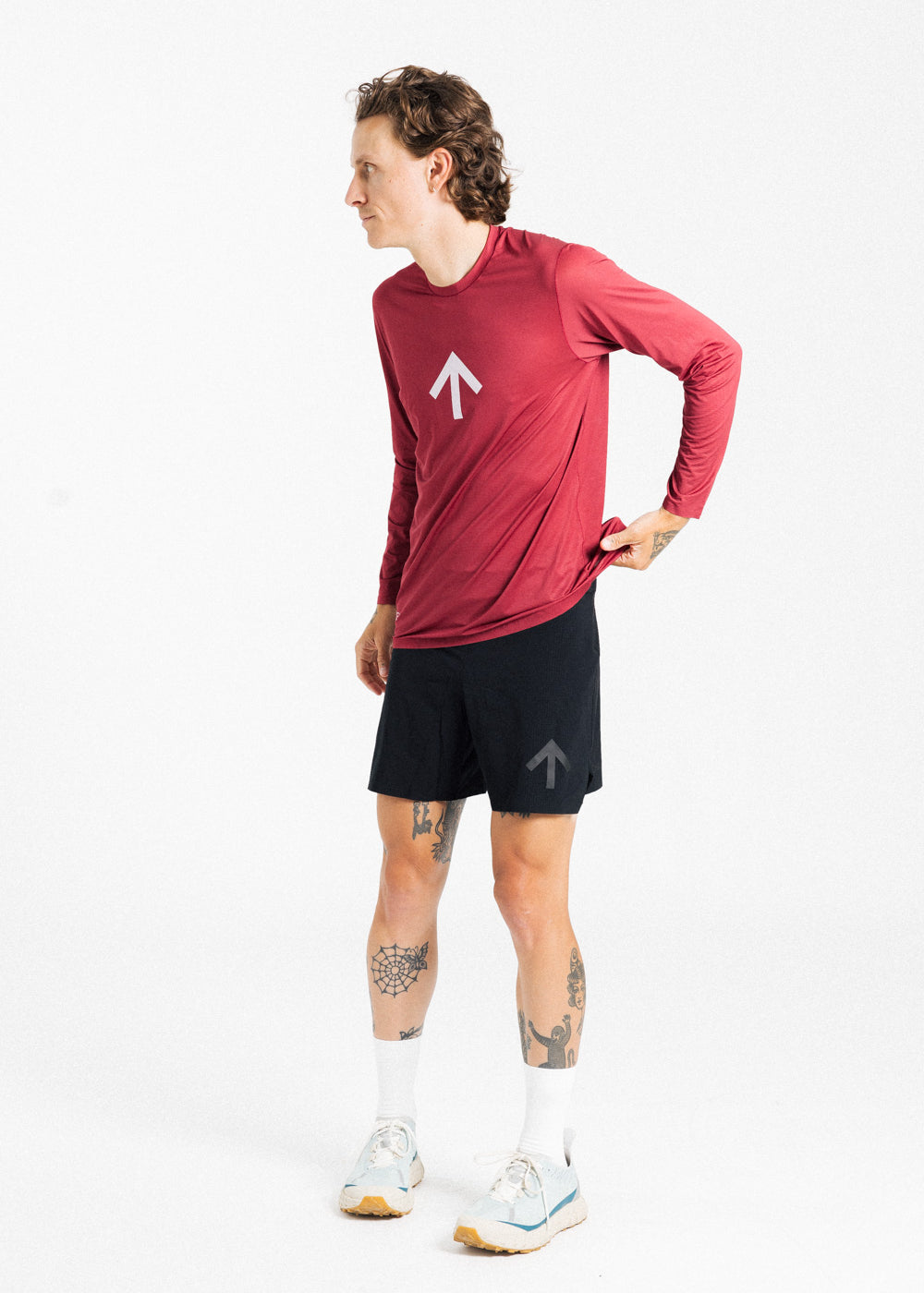 Male runner wearing the AROW Marathon Short v.2 in Black and Black with a red long sleeve top