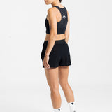 Female runner looking back, showing the white arrow on the back of the AROW Women's Running Bra