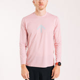 An ultra runner wearing a pink long sleeve running tee with a chrome version of the Chance Running arrow mark on the front.